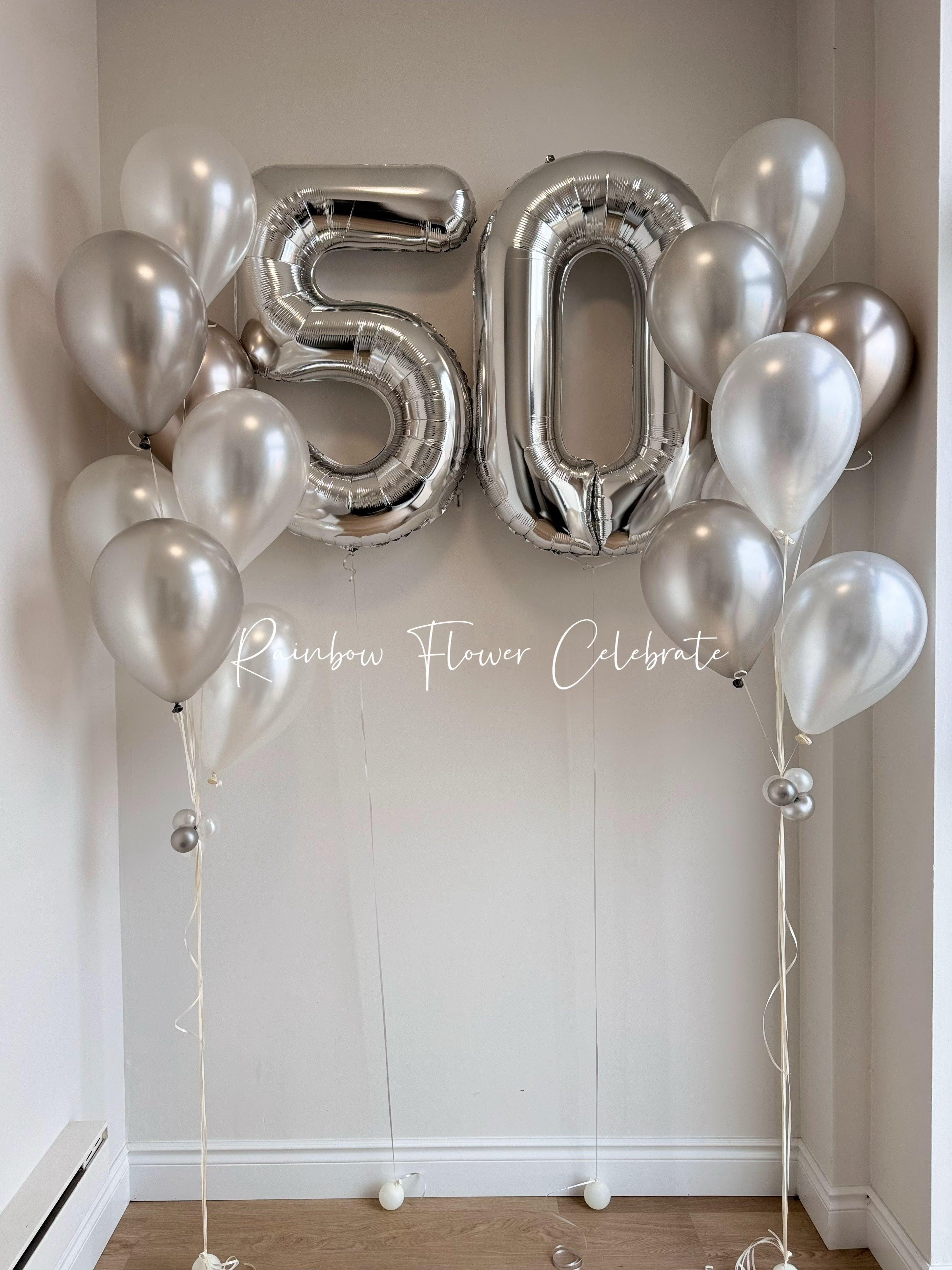 Silver 50th birthday balloon arrangement with metallic latex balloons in a white room