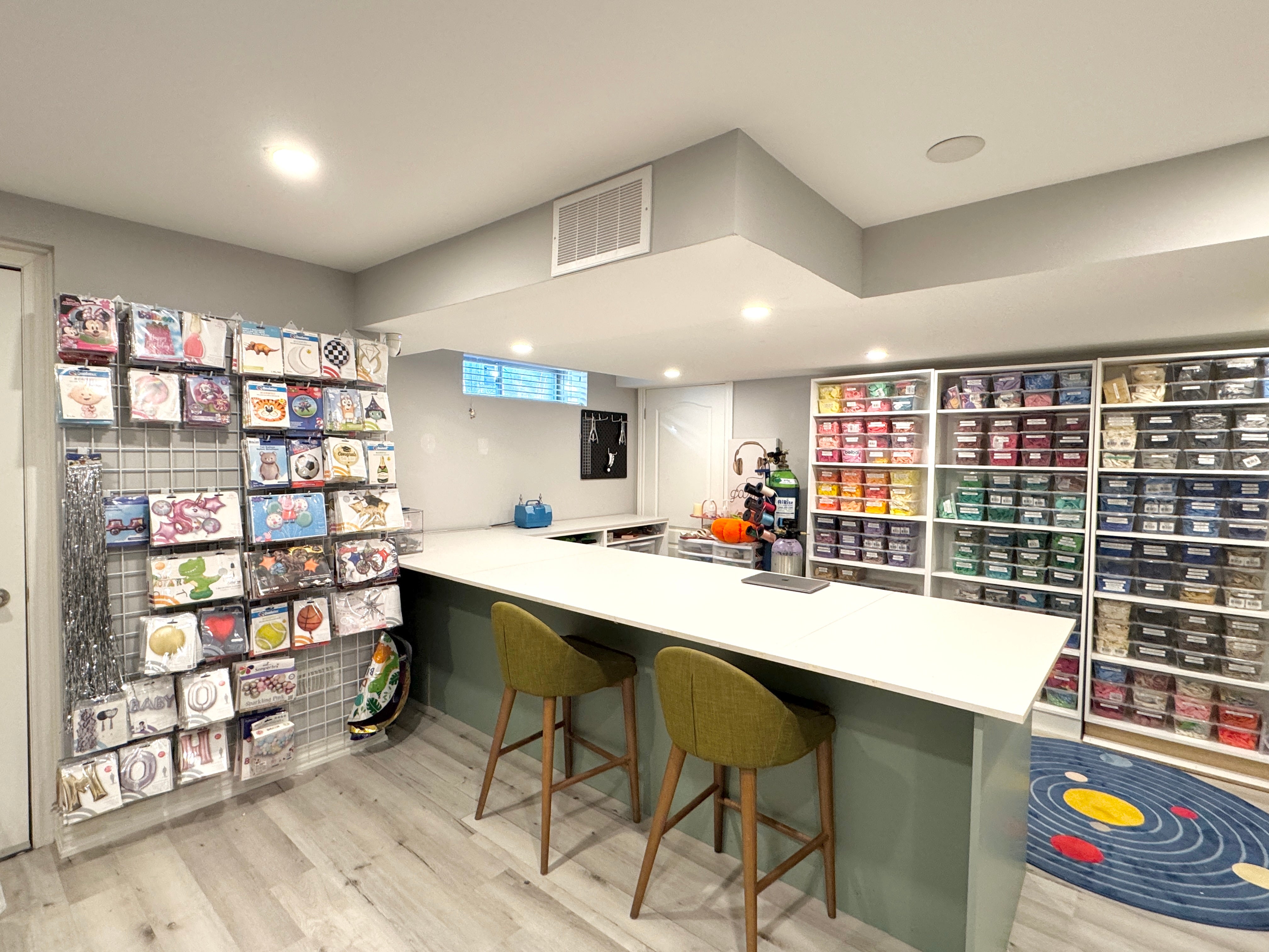 Balloon boxes of varies colours on the shelves and a oversize working station