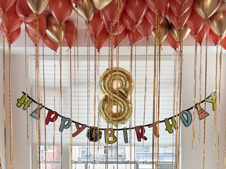 Gold and pink birthday balloons, gold number 8 balloon, and Happy Birthday banner decoration