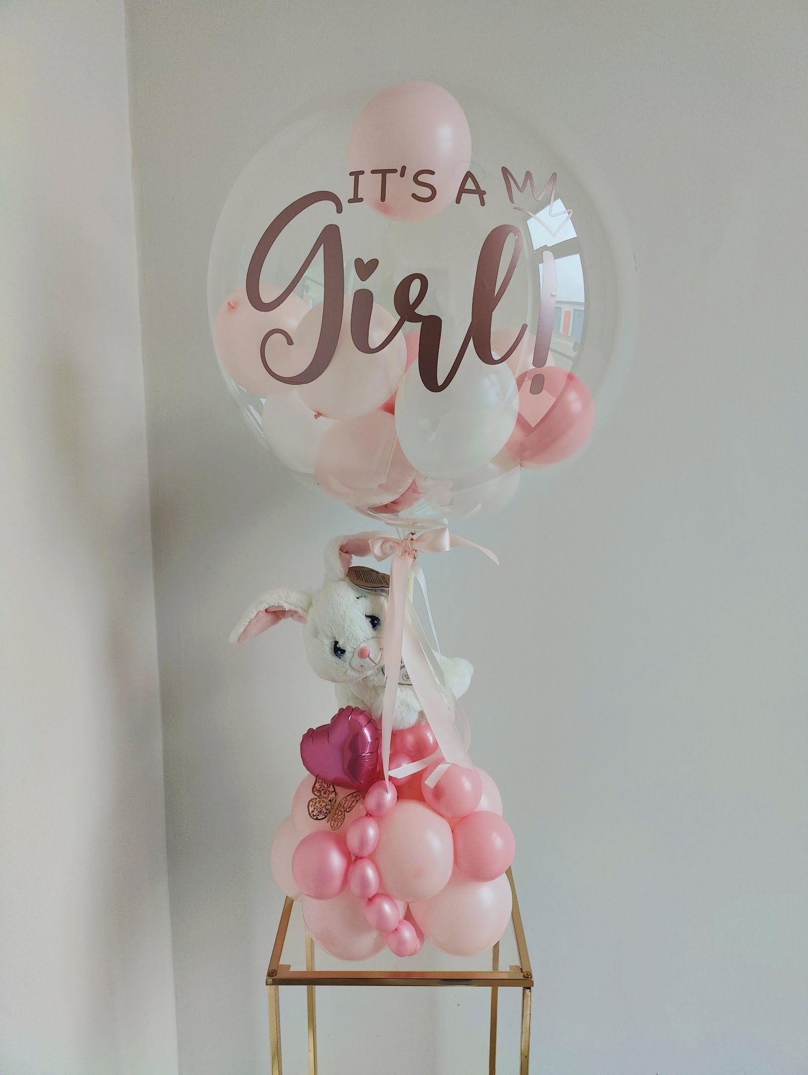 Decorative pink, baby pink and white balloon with personalized It's A Girl!  on a clear balloon with mini balloon inside, great for table top and centerpiece balloon decoration for baby shower