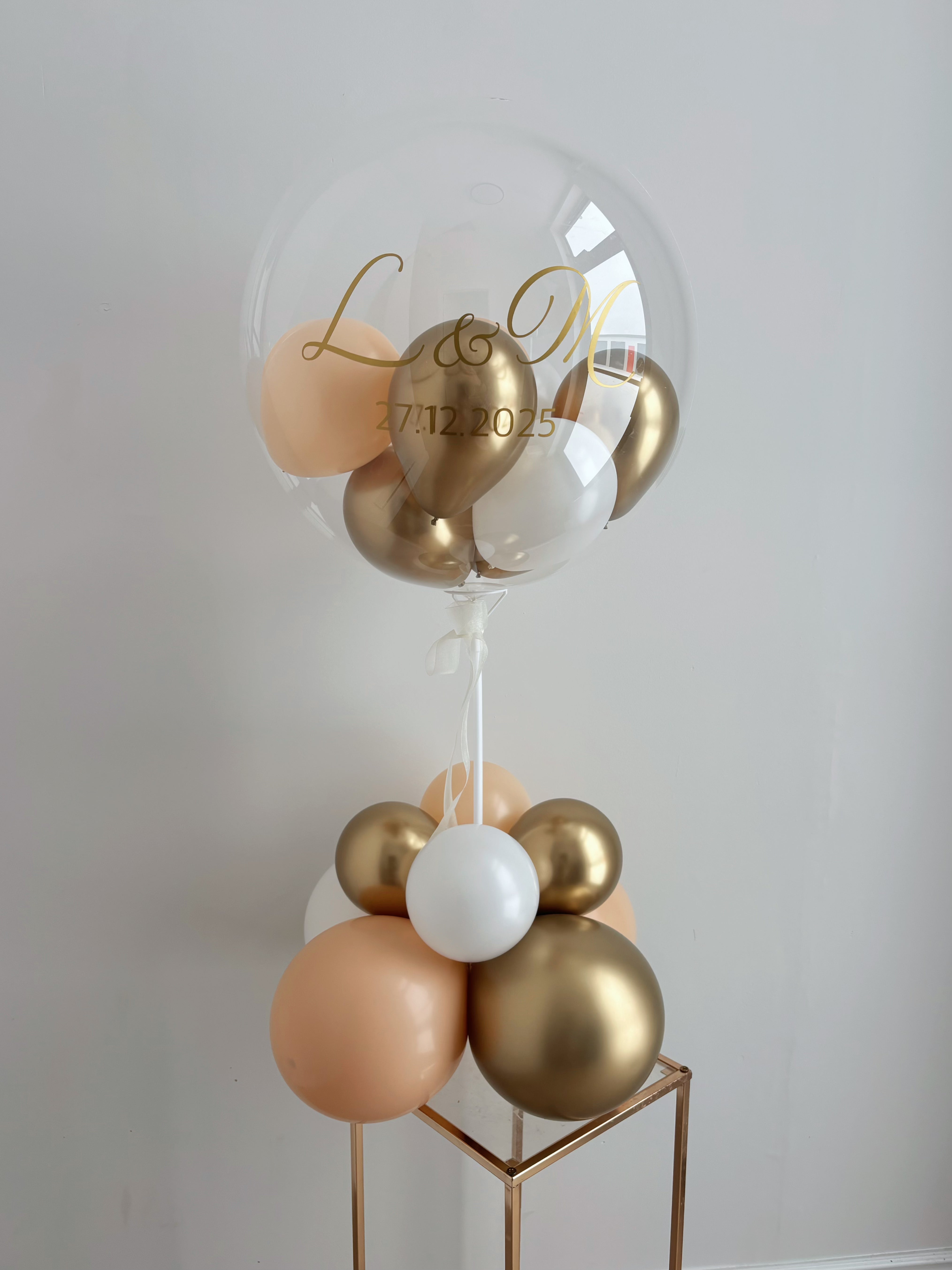 Decorative peach, gold and white balloon with personalized Initial of two letters and marriage date on a clear balloon with mini balloon inside, great for table top and center-pieces balloon decoration for Just Married!